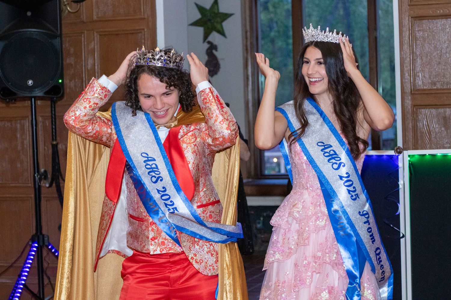 Pageant contestants in colorful dresses posing together at formal event.