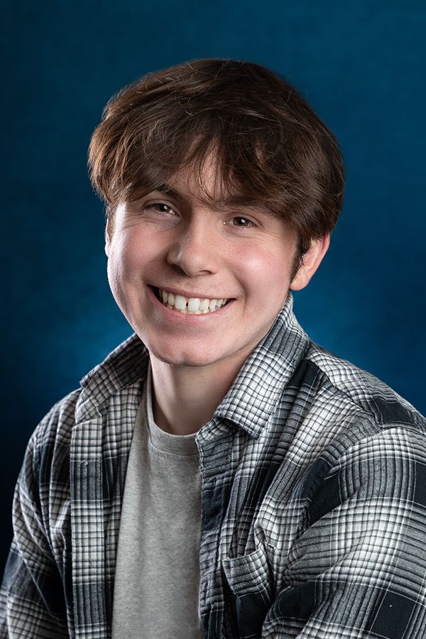 Portrait series against blue background showing playful expressions in plaid shirt.