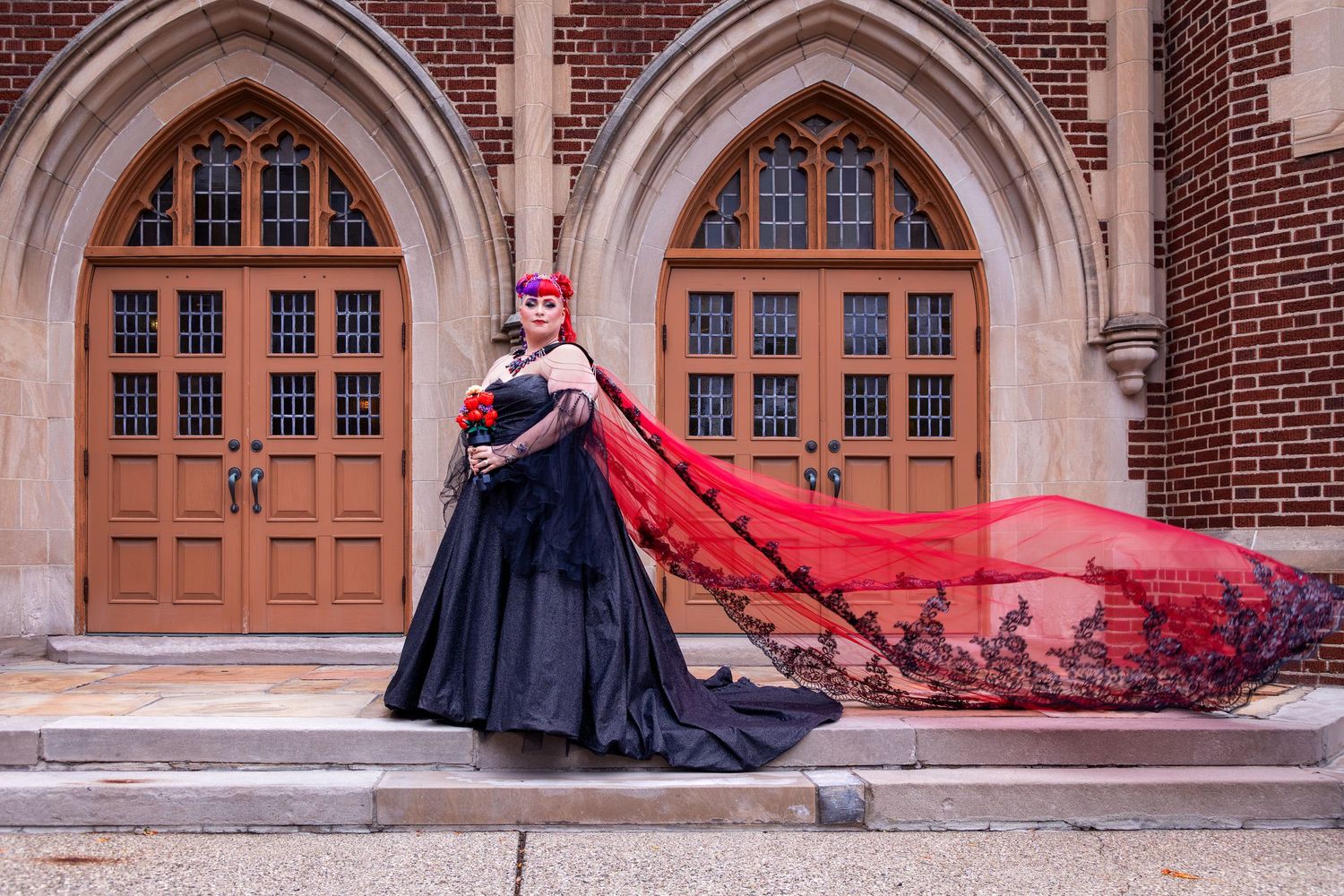 Dramatic wedding photos against Gothic architecture with flowing red cape.