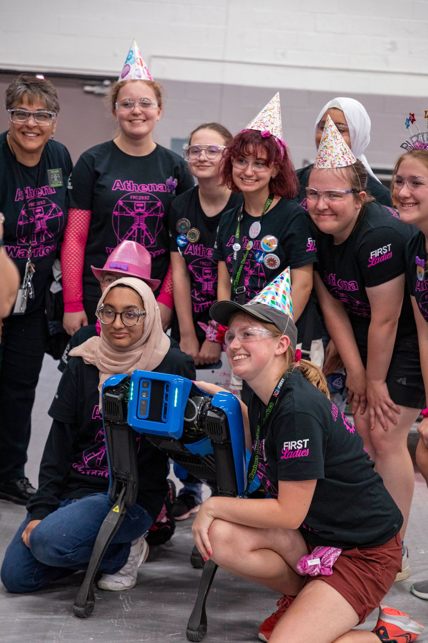 Team members in matching pink and black uniforms posing together for a group photo.