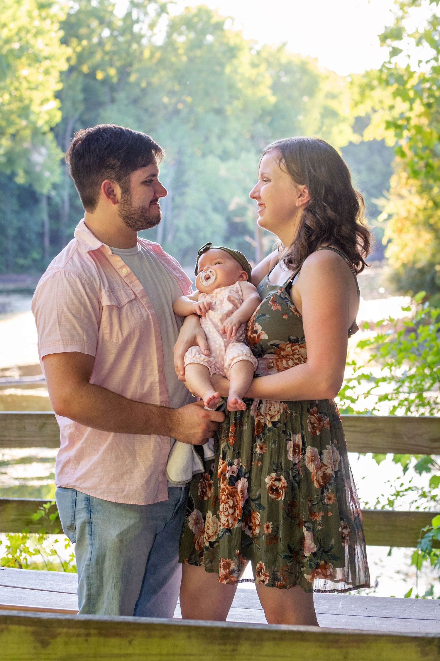 Family portrait series by lake showing tender moments with baby during golden hour.
