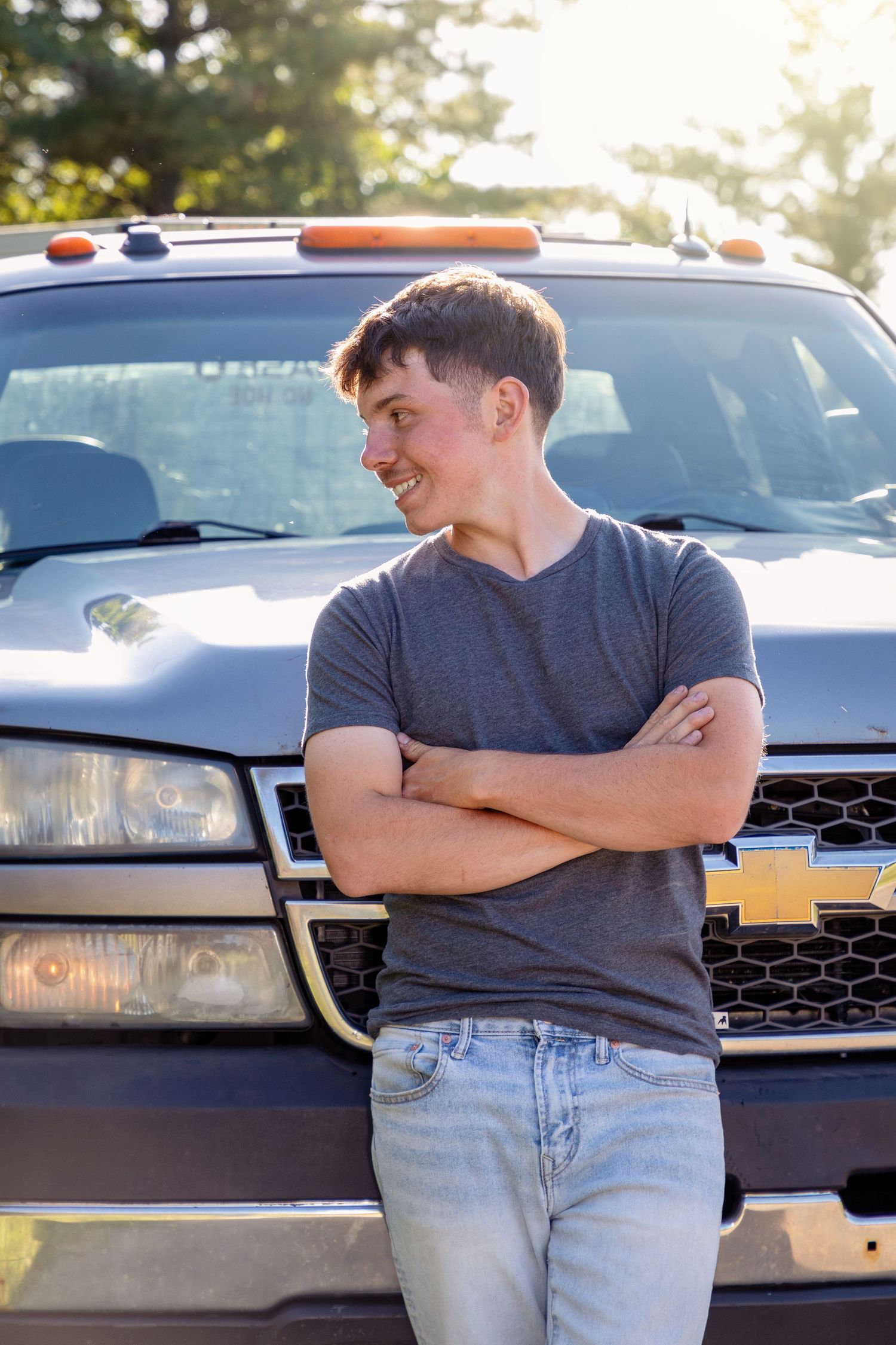 A casual portrait leaning against a Chevrolet truck during golden hour.