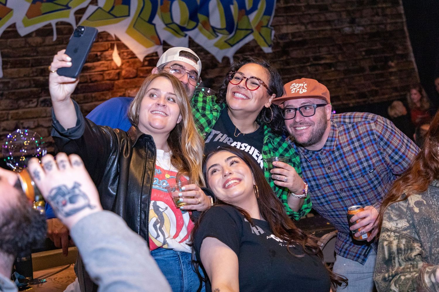 Party guests enjoying themselves and taking selfies at a casual celebration.