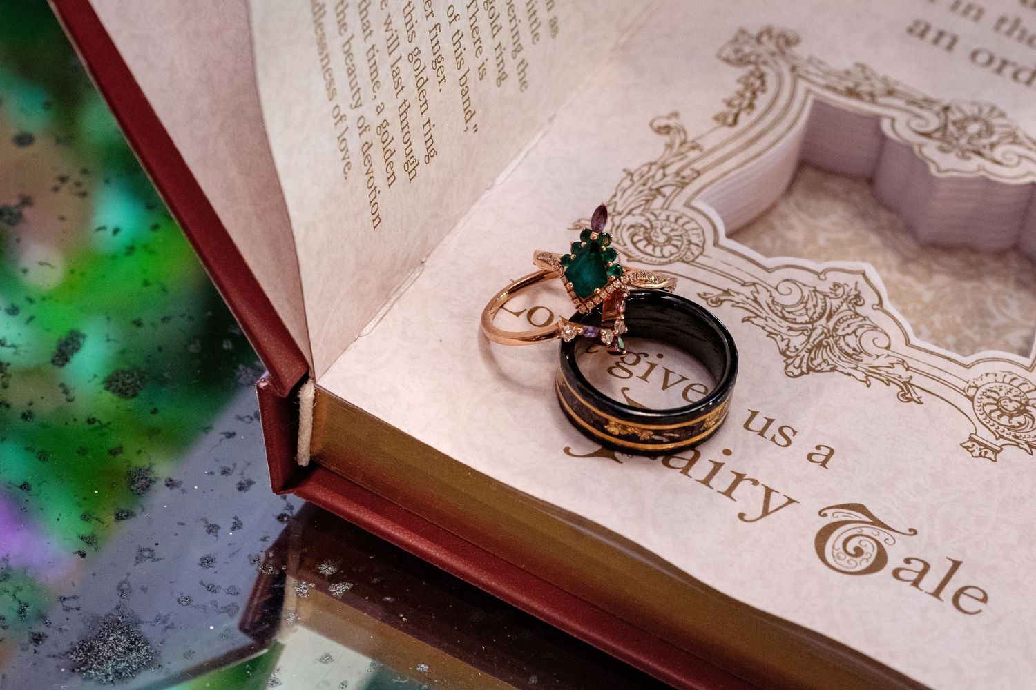 Vintage fairy tale book with antique compass and ring resting on ornate text page.