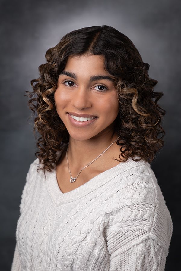 Portrait series showing person in white cable knit sweater against gray background.