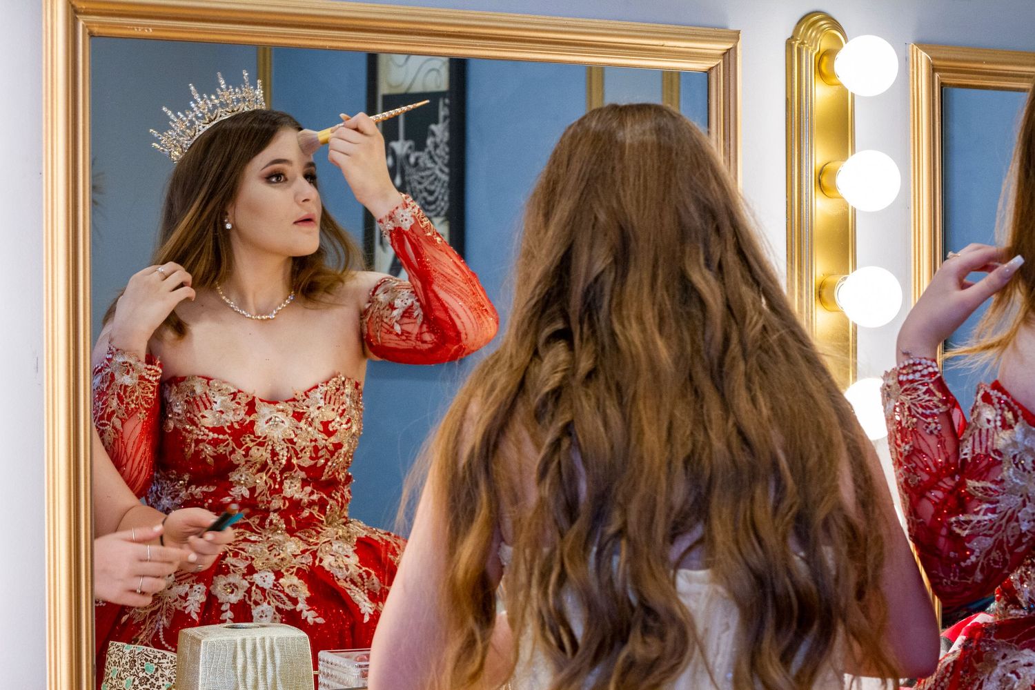 A vanity mirror reflection showing someone preparing for a special occasion.