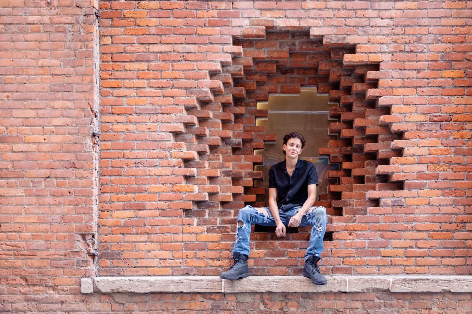 Creative portrait series taken in brick wall alcove.