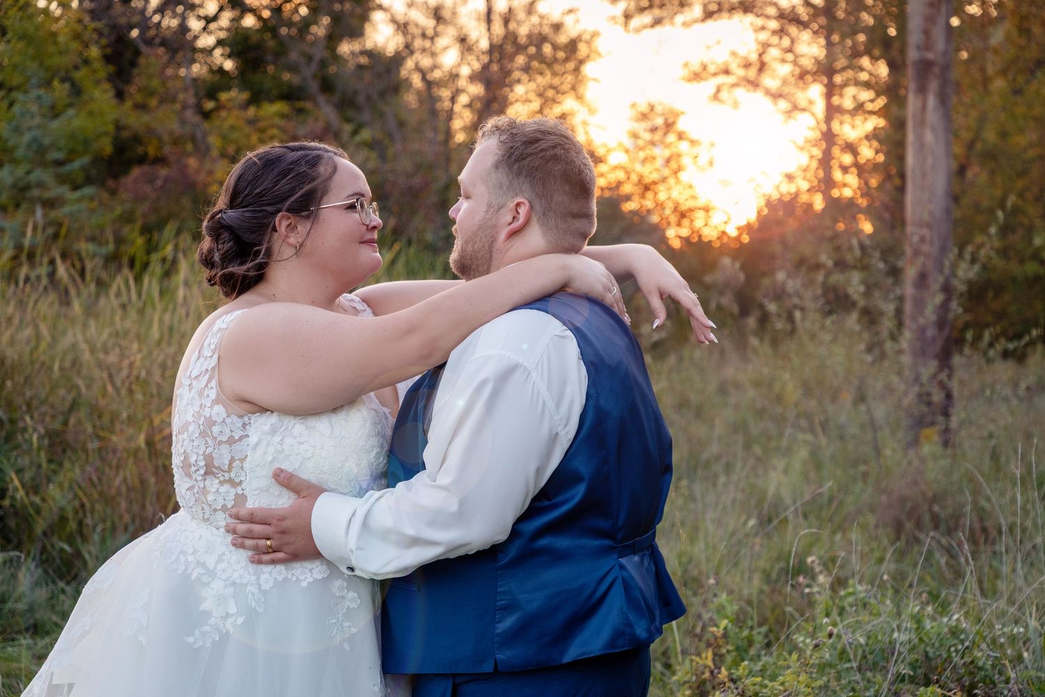 Intimate sunset wedding portrait in a golden field.