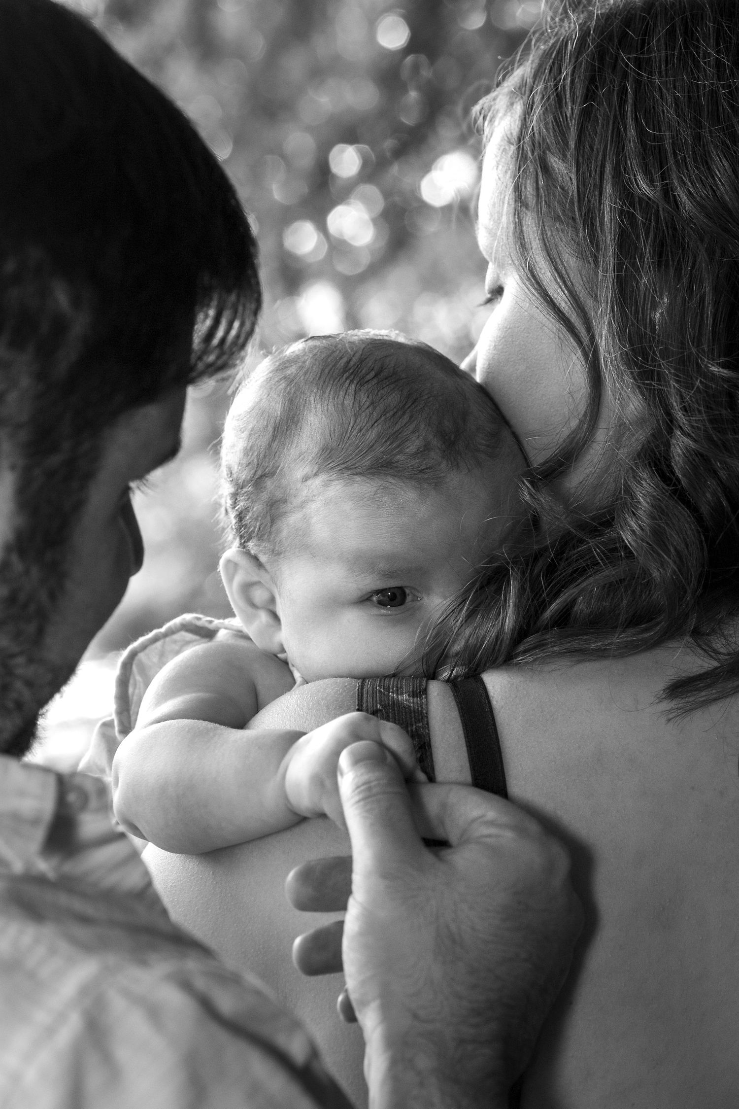 Close-up black and white shots capturing intimate family moments with bokeh background.