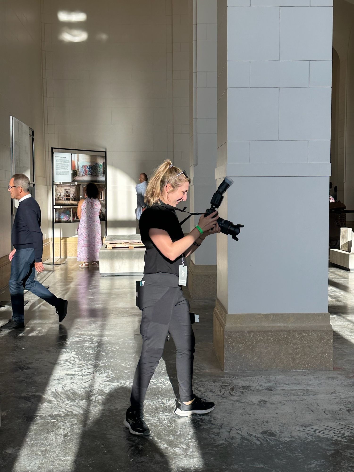 People photographing in an empty concrete hallway with dramatic lighting.