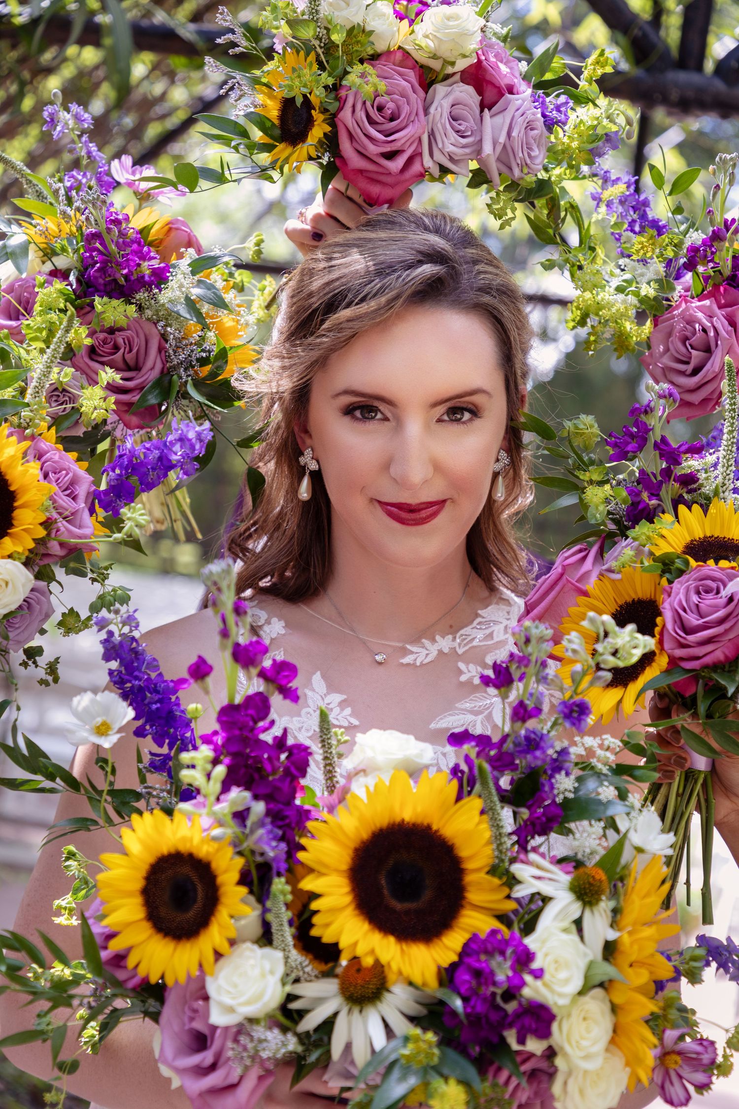 Vibrant bridal bouquet featuring sunflowers, purple flowers, and pink roses with floral crown.