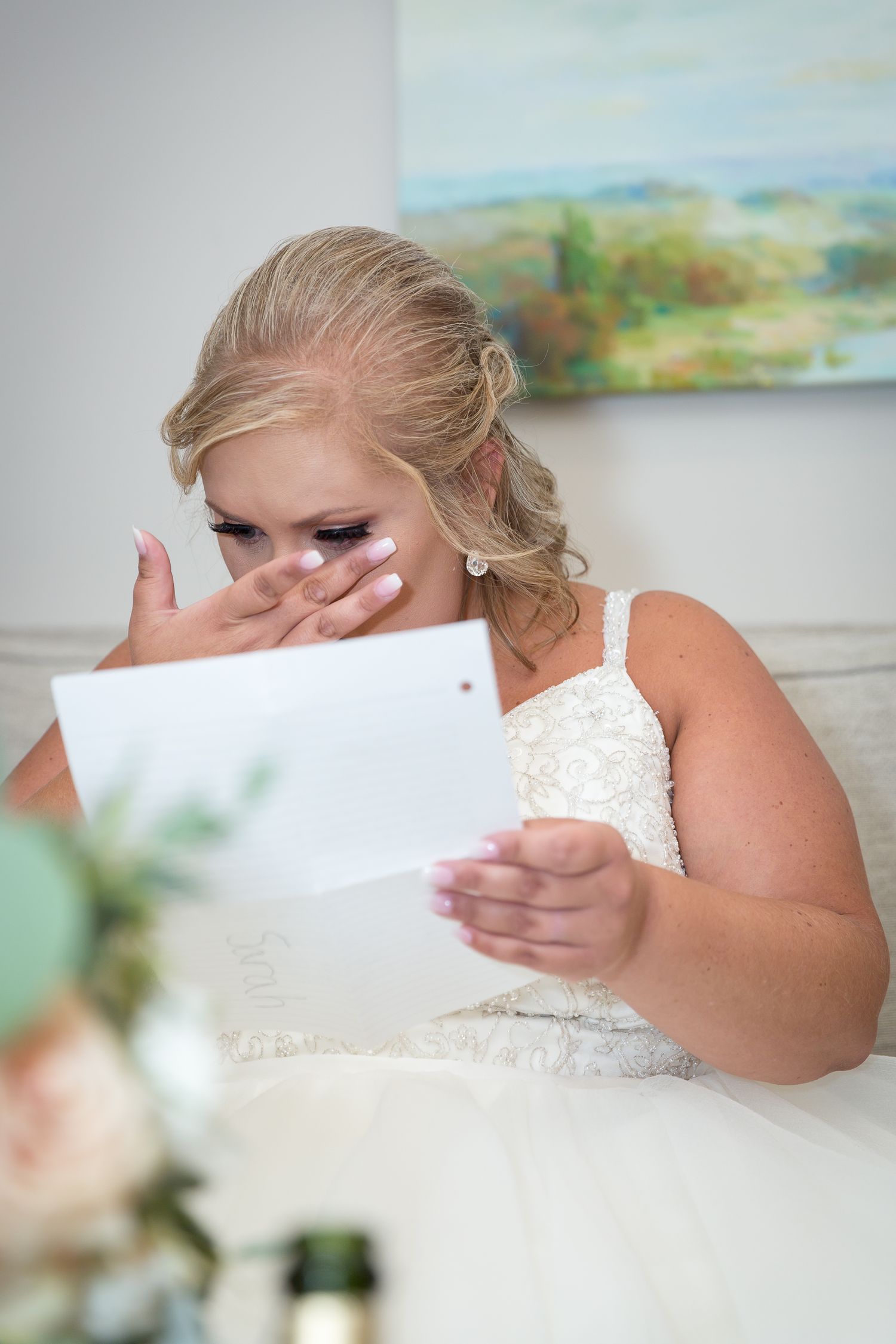 bride reading letter from groom crying and wiping tear