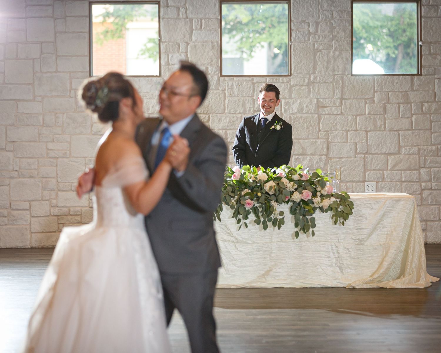 groom watching his bride and her father dancing at their reception at Walters wedding venue
