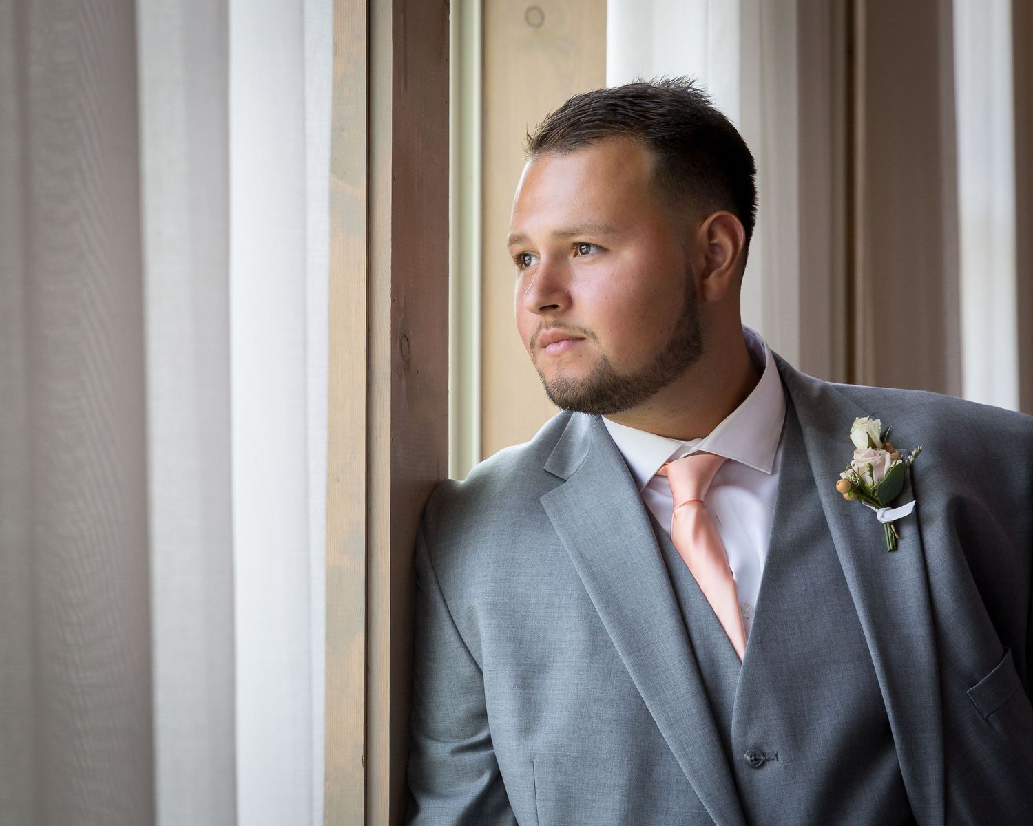 groom in grey suite with pink tie at Walters wedding venue