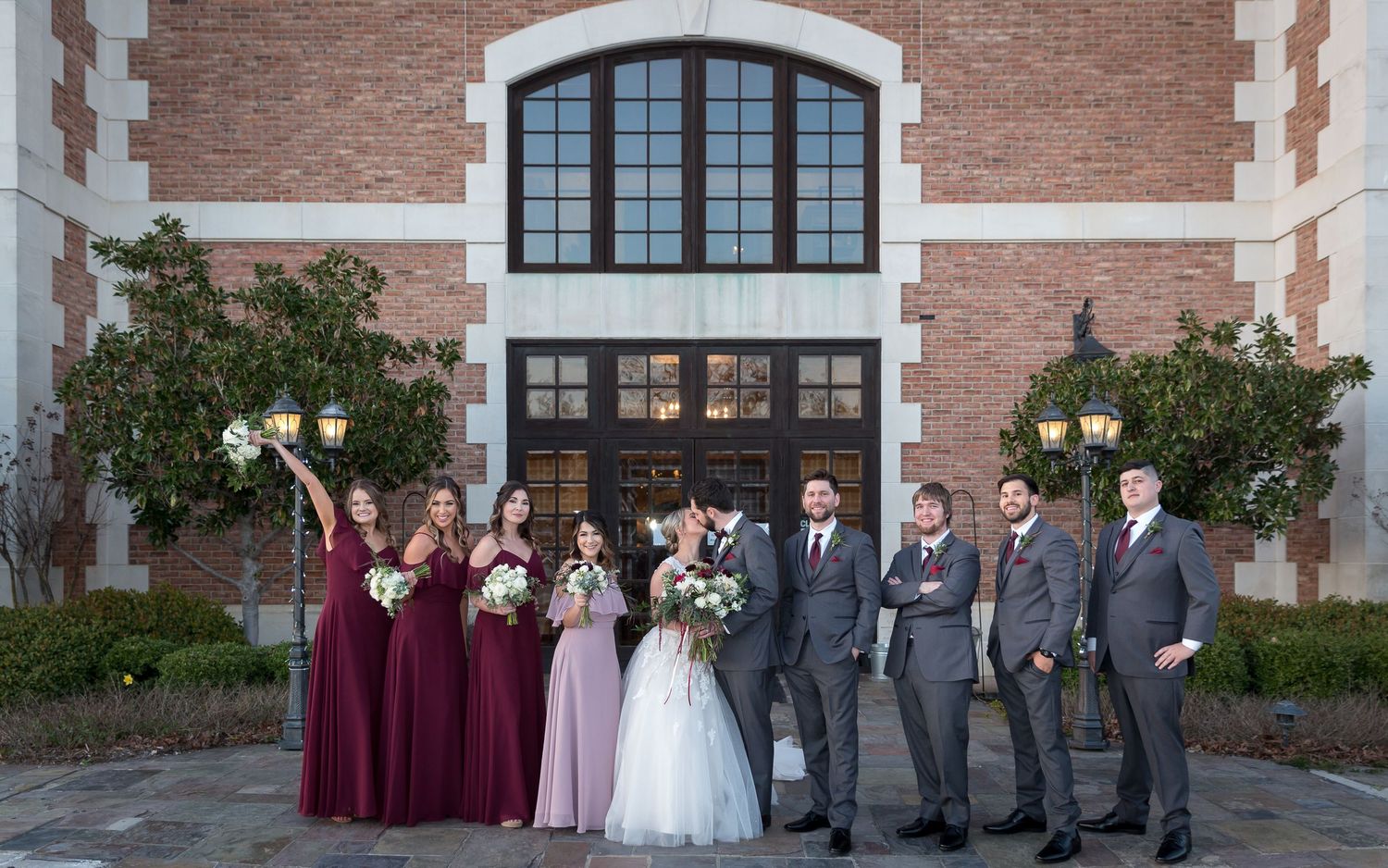 bride and groom with their wedding party in front of winery