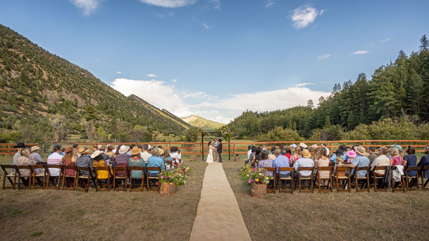bride and groom at alter in the mountains of Durango Colorado with family and friends on sunny day