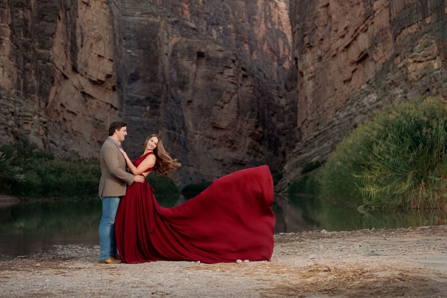 autumn engagement session in front of the Santa Elana canyon with the bride to be wearing a custom red maroon long flowing gown