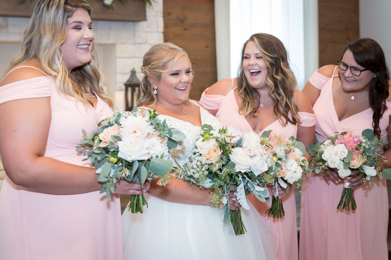 bride and wedding party bridesmaids wearing pink laughing