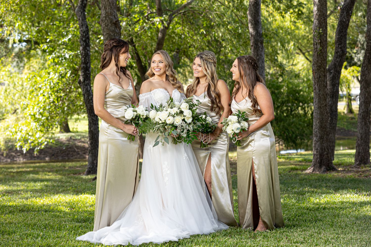 bride and her wedding party brides maids in gold on the lawn of a wooded wedding venue