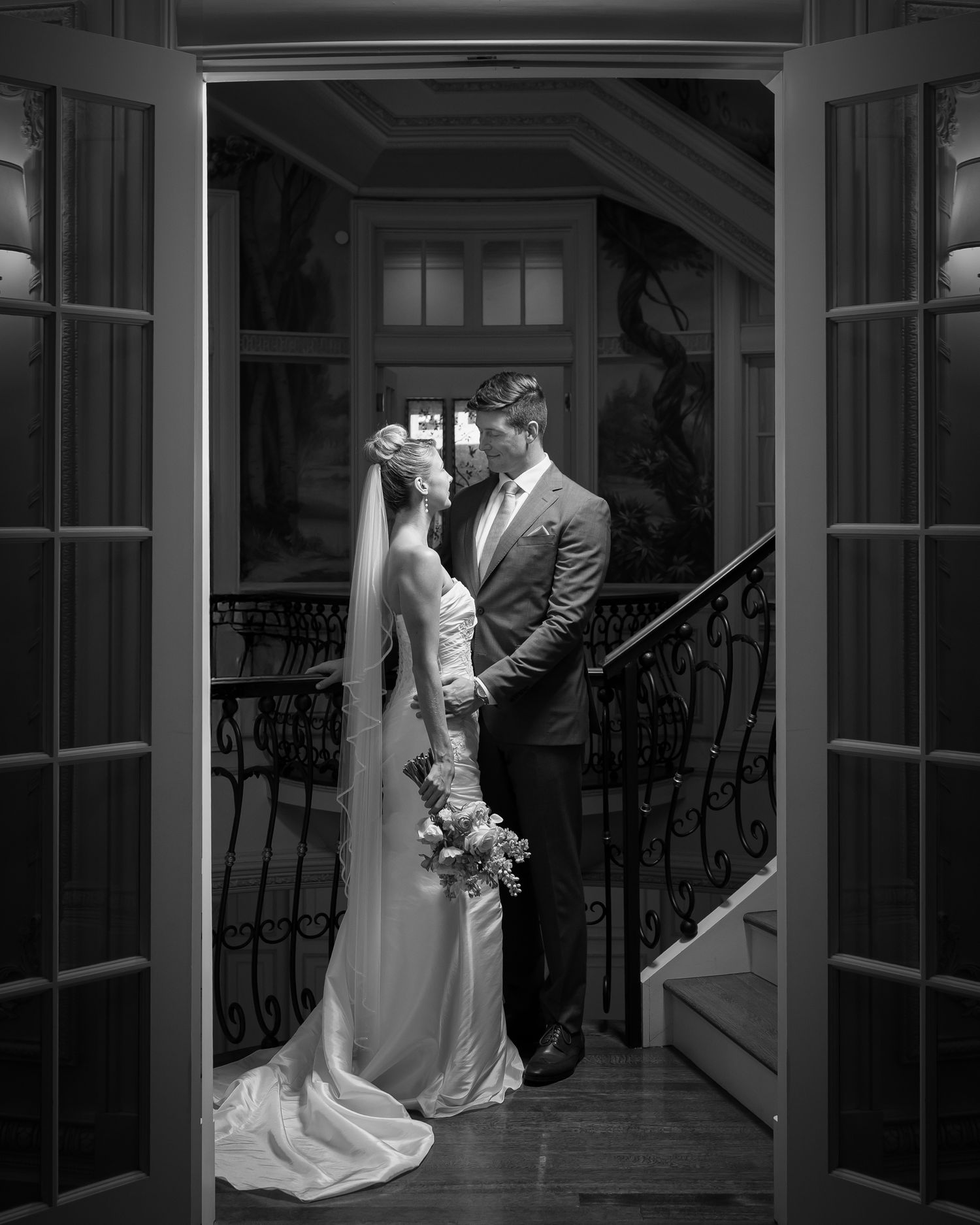 black and white image of bride and groom in the doorway to the atrium of the Olana