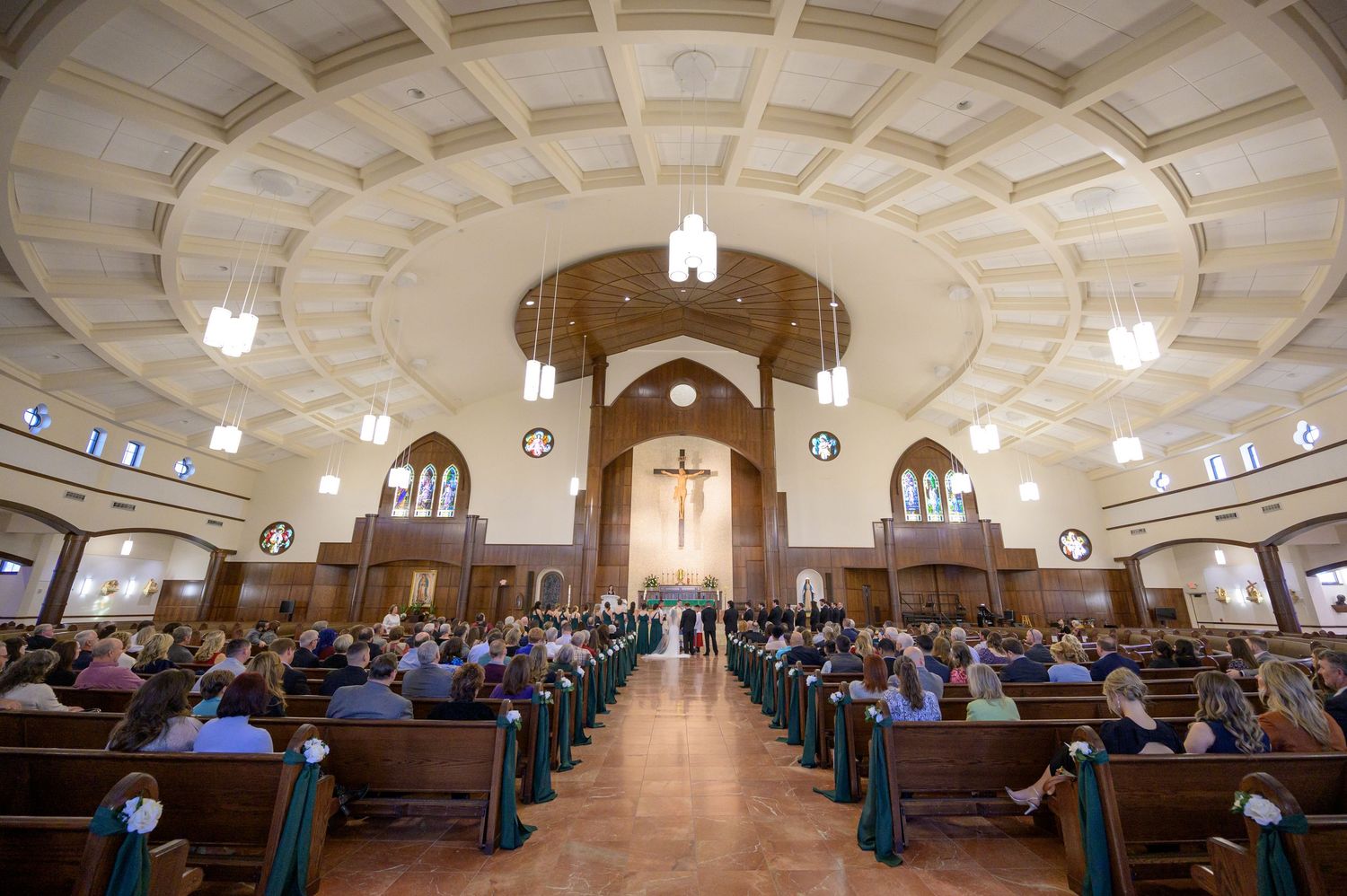 catholic couple wedding ceremony full view of church and pews