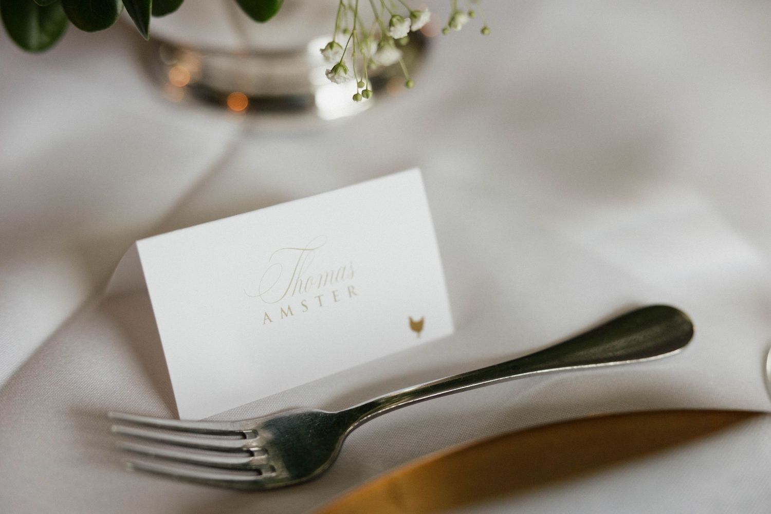 Wedding place settings with elegant white napkins and silverware on a formal dining table.