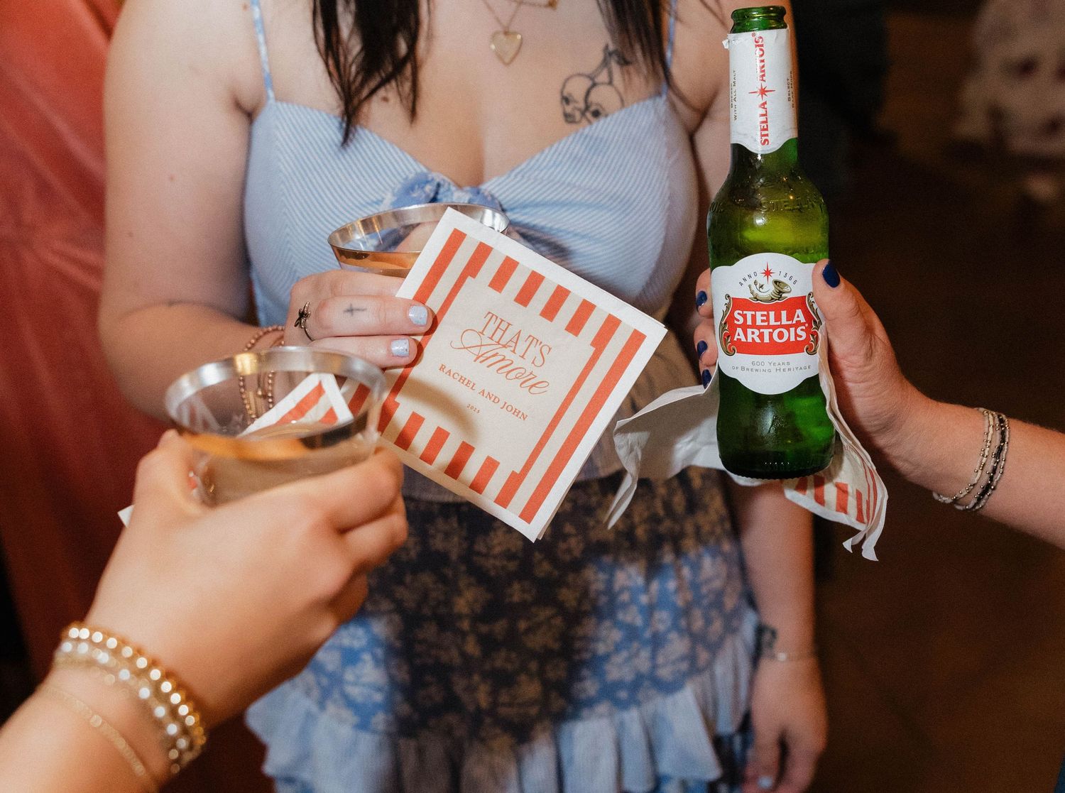 Wedding guests holding striped favor boxes at reception celebration.