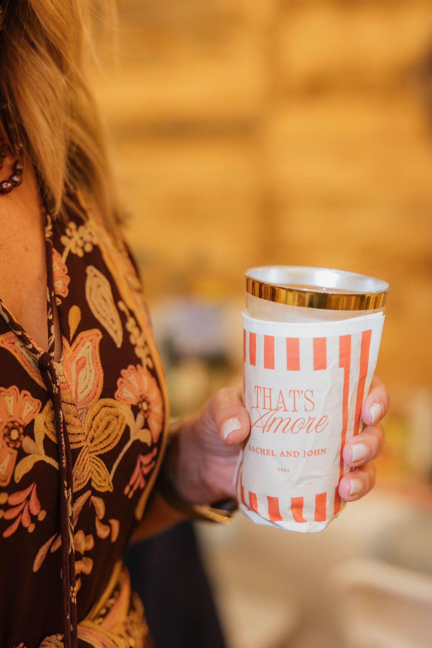 Striped pink and white paper cups with decorative text at a celebration.