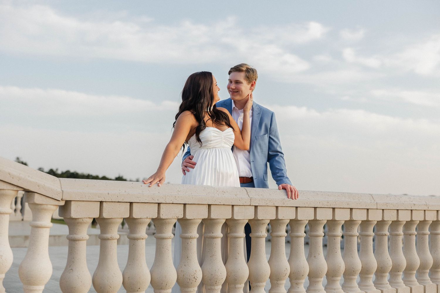 Couple enjoying sunset views from an elegant white balustrade terrace.