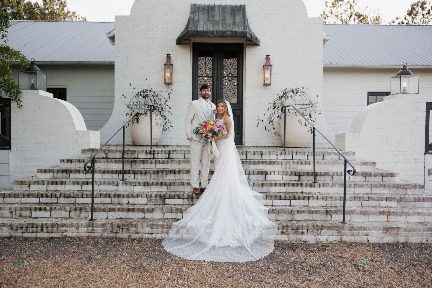 Classic white wedding venue with stone steps and elegant entrance.