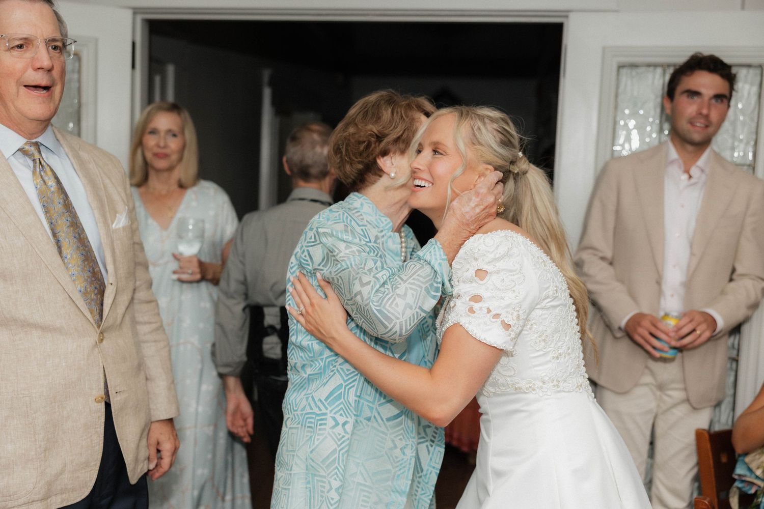 Wedding guests share emotional moments and hugs during a celebration.
