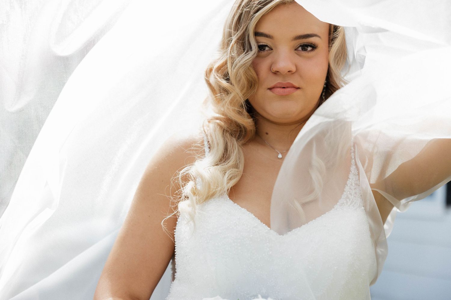 Ethereal bridal portraits with flowing white fabric against bright background.