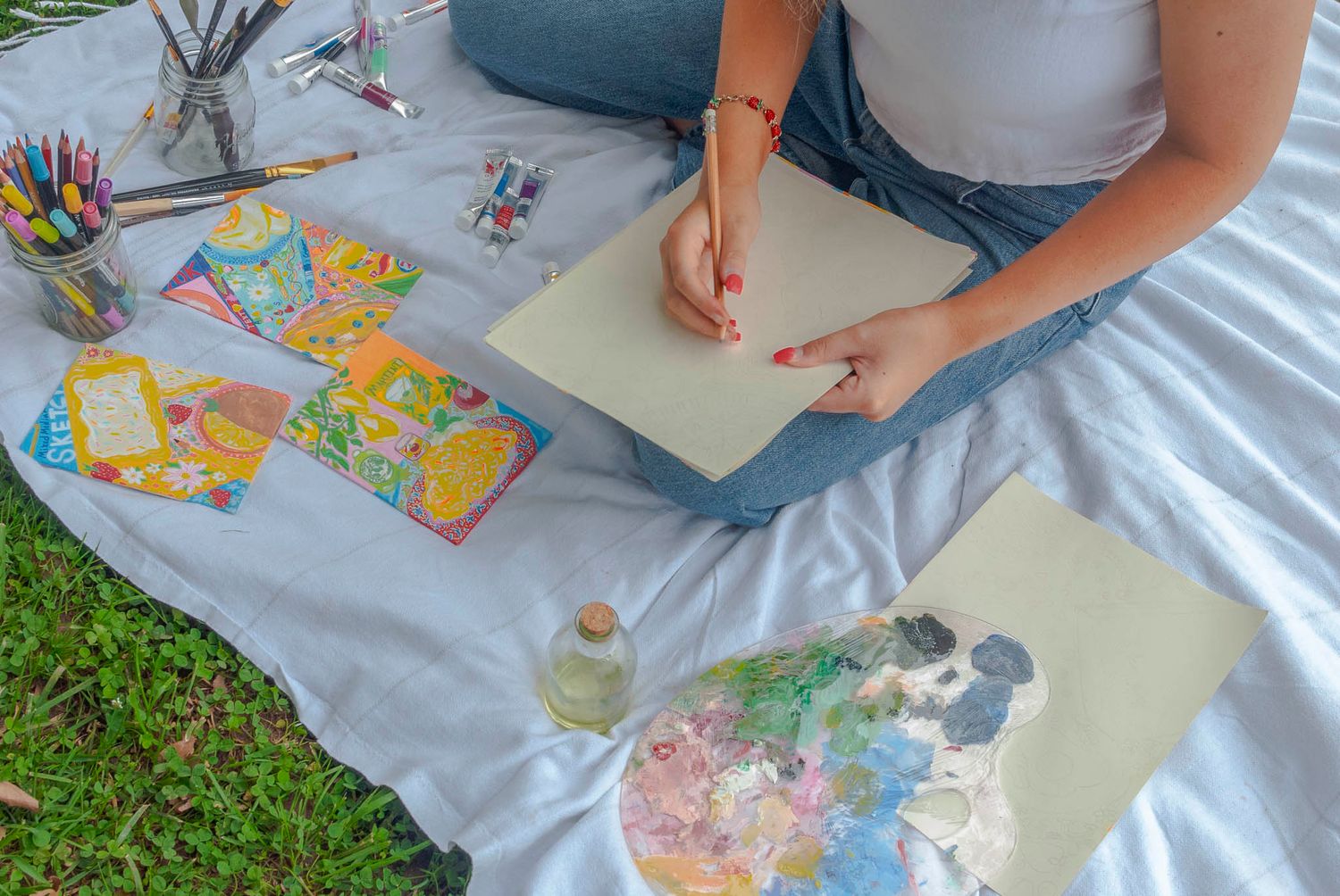 Artist sketching sitting on a picnic blanket outdoor during a branding photography session