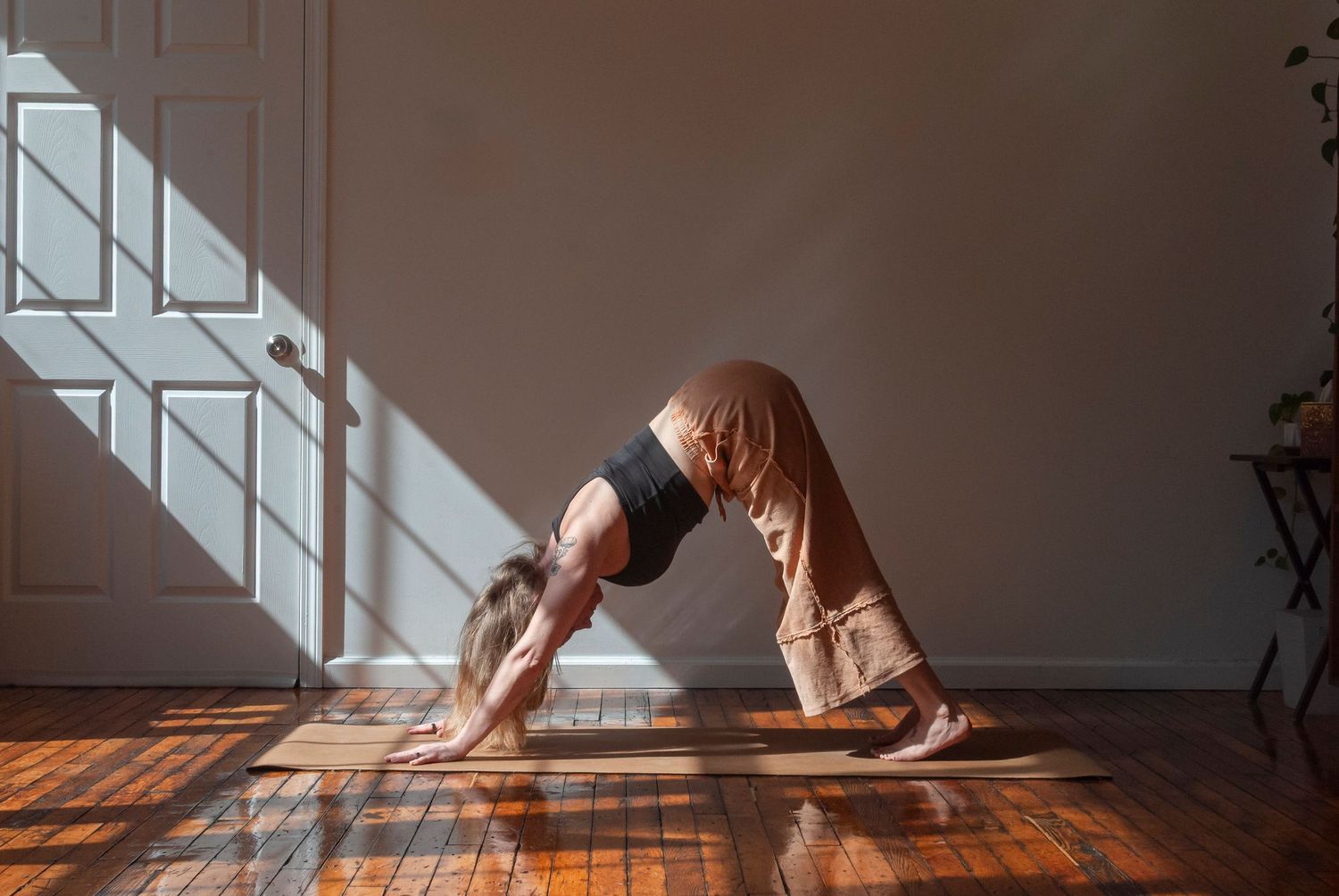 Photograph of a woman practicing yoga indoors in natural light