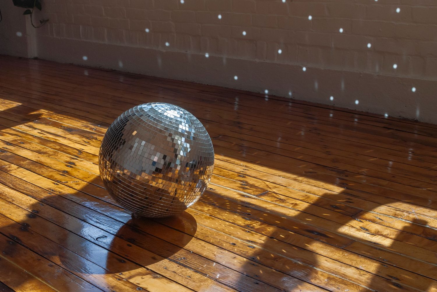 Disco ball on floor of sun lit yoga studio