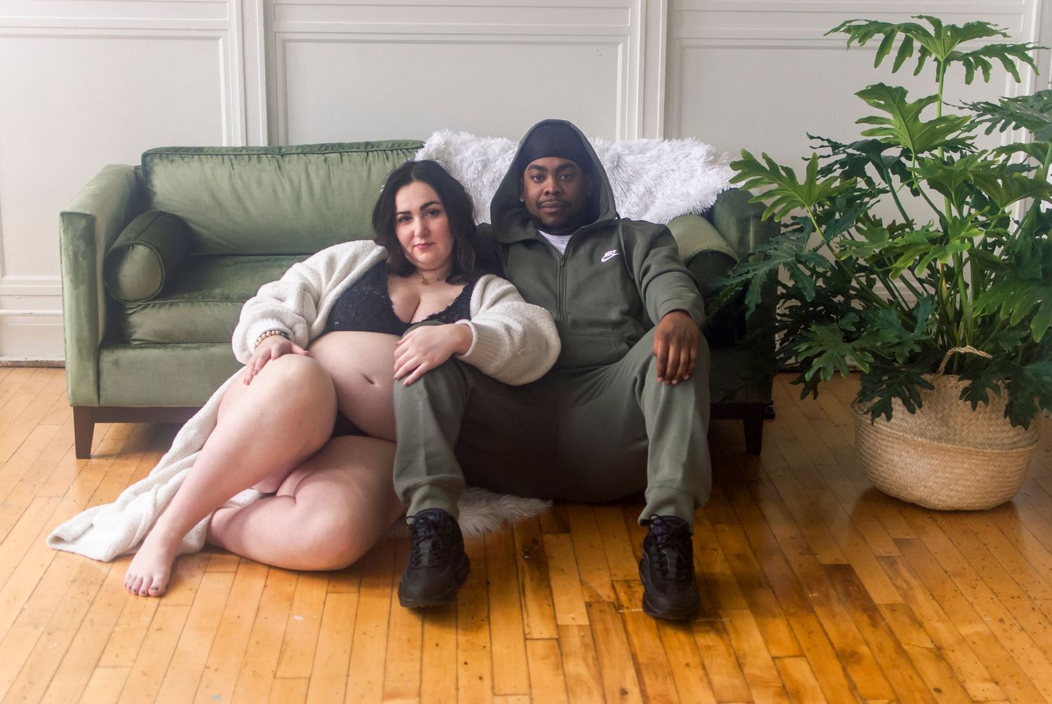 Maternity portrait of a couple sitting on the floor in a curated, natural light photography studios in Hartford, CT