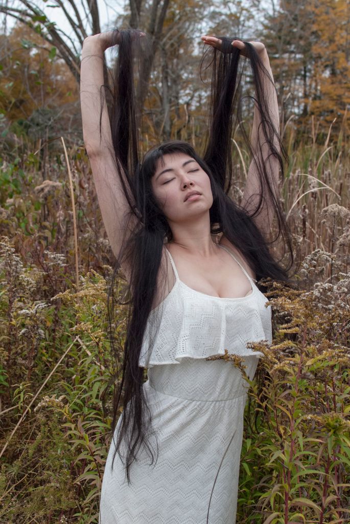 Portrait of young women with long hair outdoors in tall grass