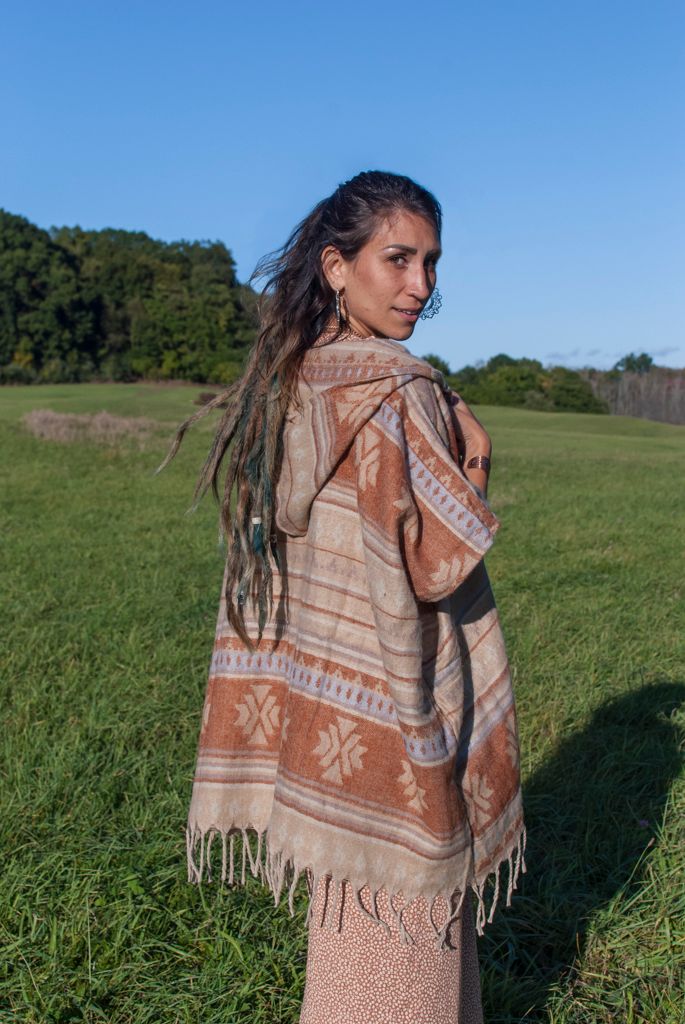 Commercial photography of a young woman modeling a bohemian shawl outdoors in a field