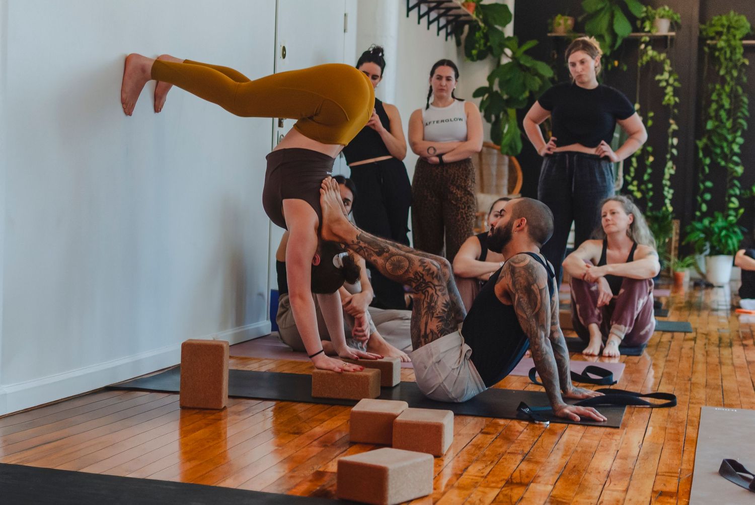 Yoga teacher assisting a student during a yoga workshop in a studio located in Hartford, CT