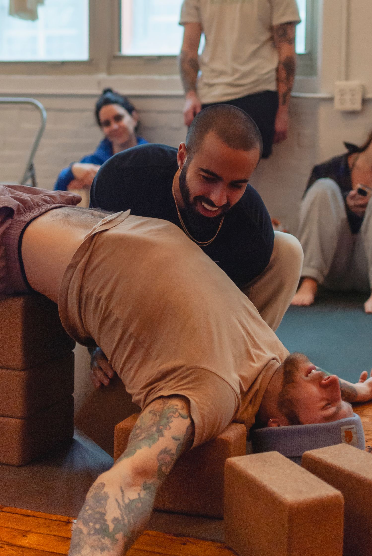 Yoga teacher assisting a student during a yoga workshop in a studio located in Hartford, CT