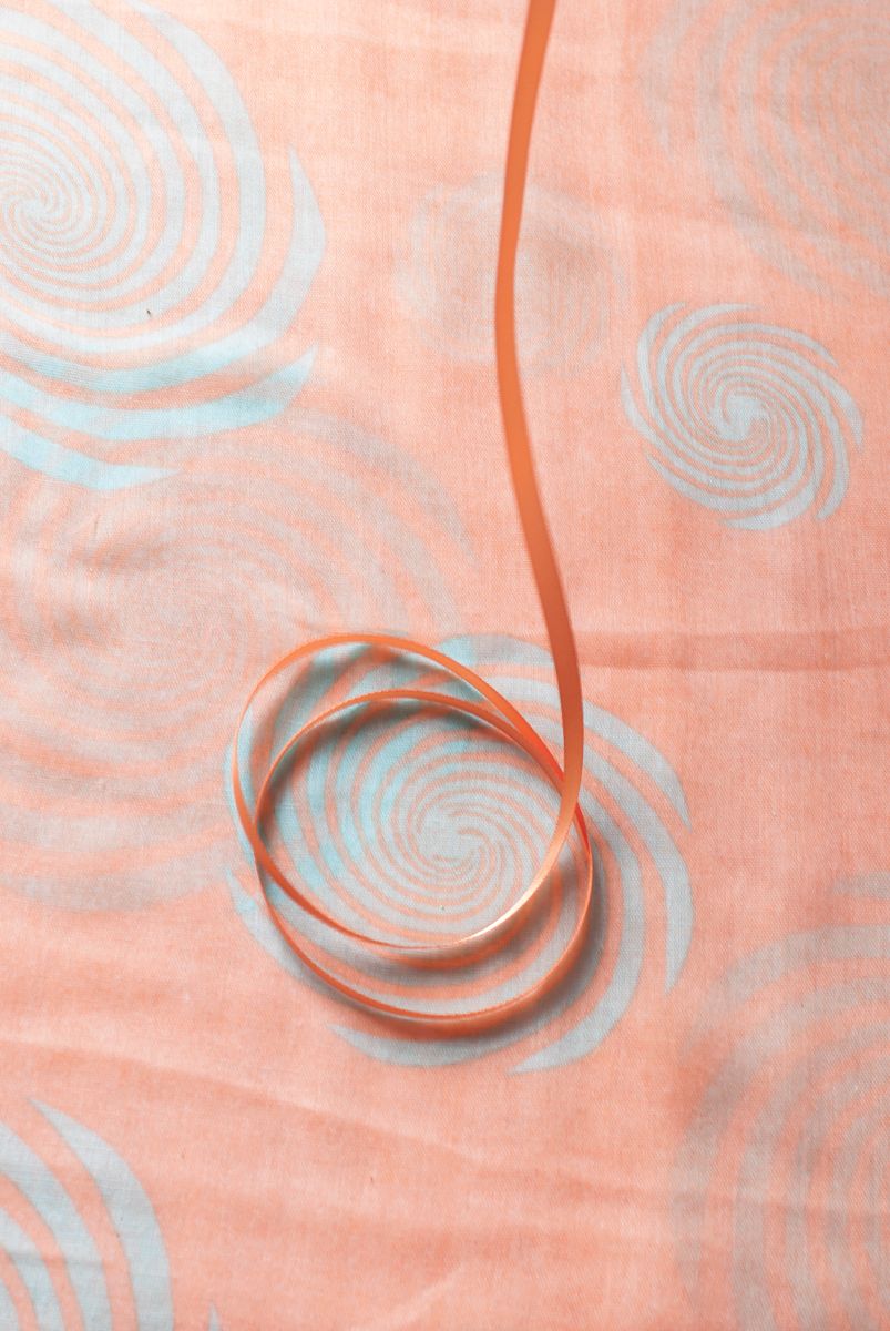 Close up detail of a pink ribbon on a pink scarf
