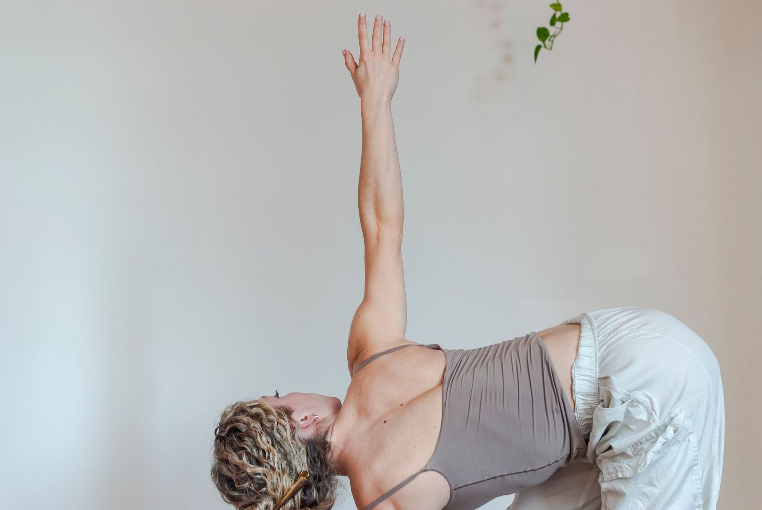 Photograph of a woman practicing yoga indoors in a yoga studio