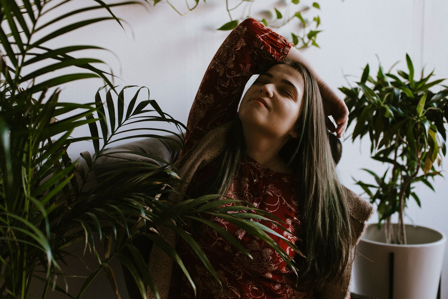 The photographer (Kristen McNevins) surround by plants in a New York City photo studio