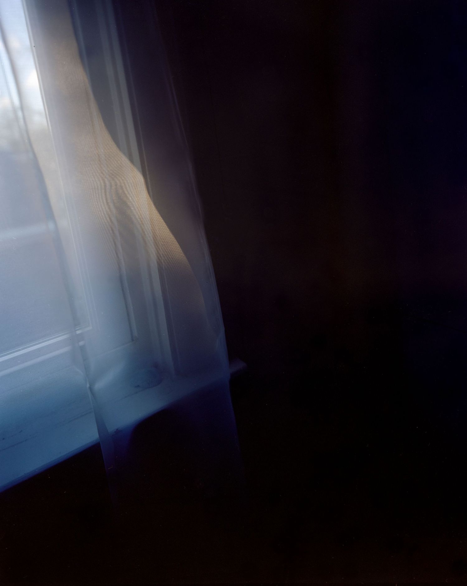 Photograph of light streaming through curtains