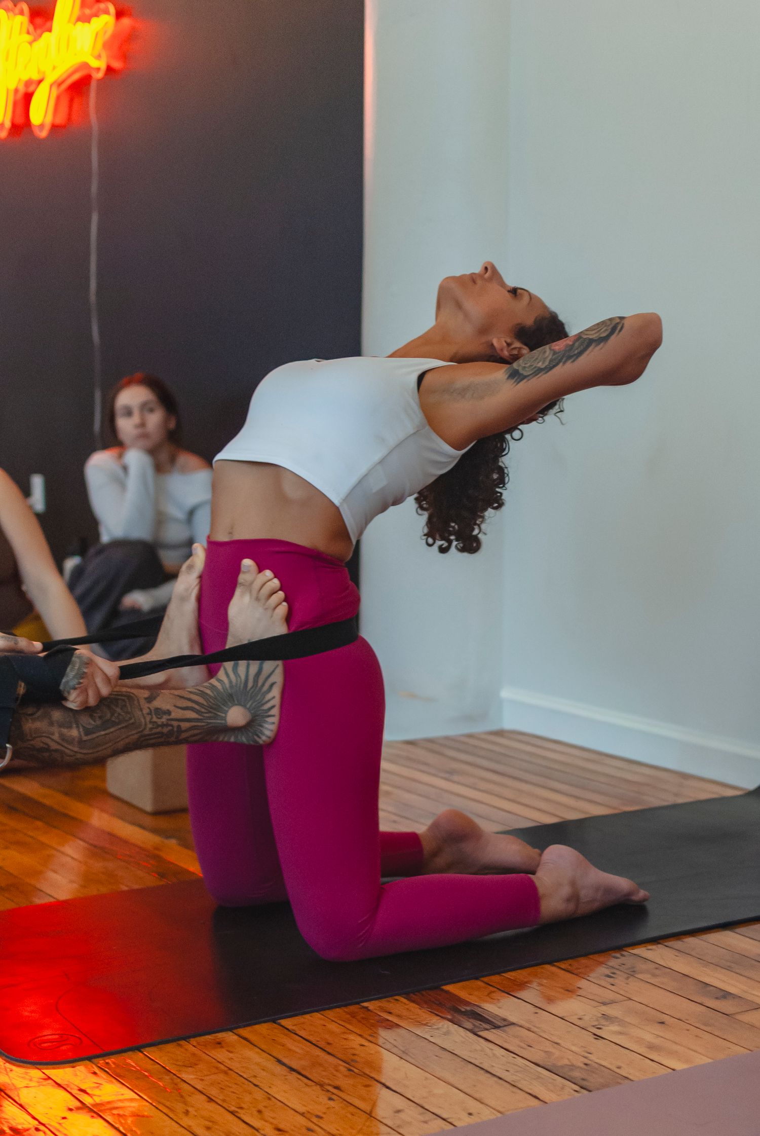 Yoga teacher assisting a student during a yoga workshop in a studio located in Hartford, CT