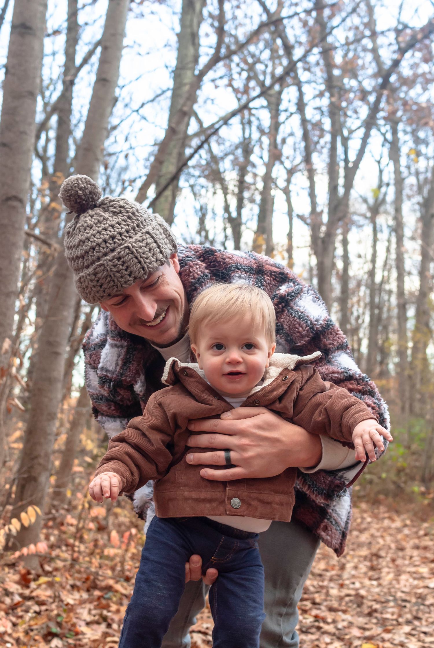 Family portrait of parents and young child outdoors in a wooded autumn setting