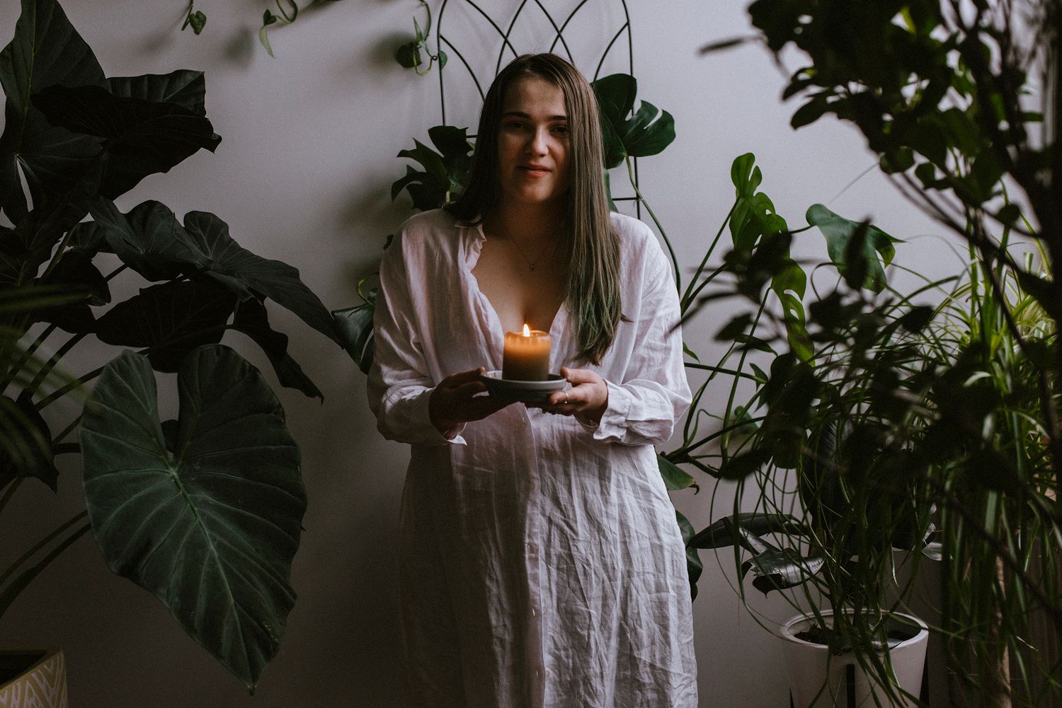 The photographer (Kristen McNevins) surround by plants in a New York City photo studio