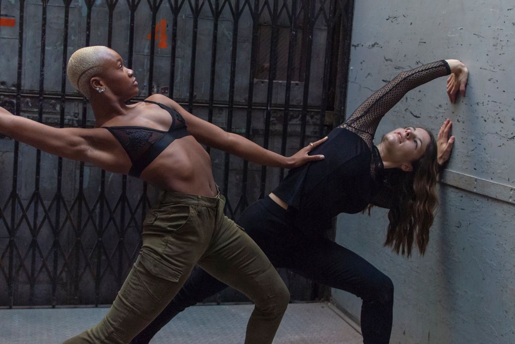 Two dancers posing in a freight elevator of an industrial building