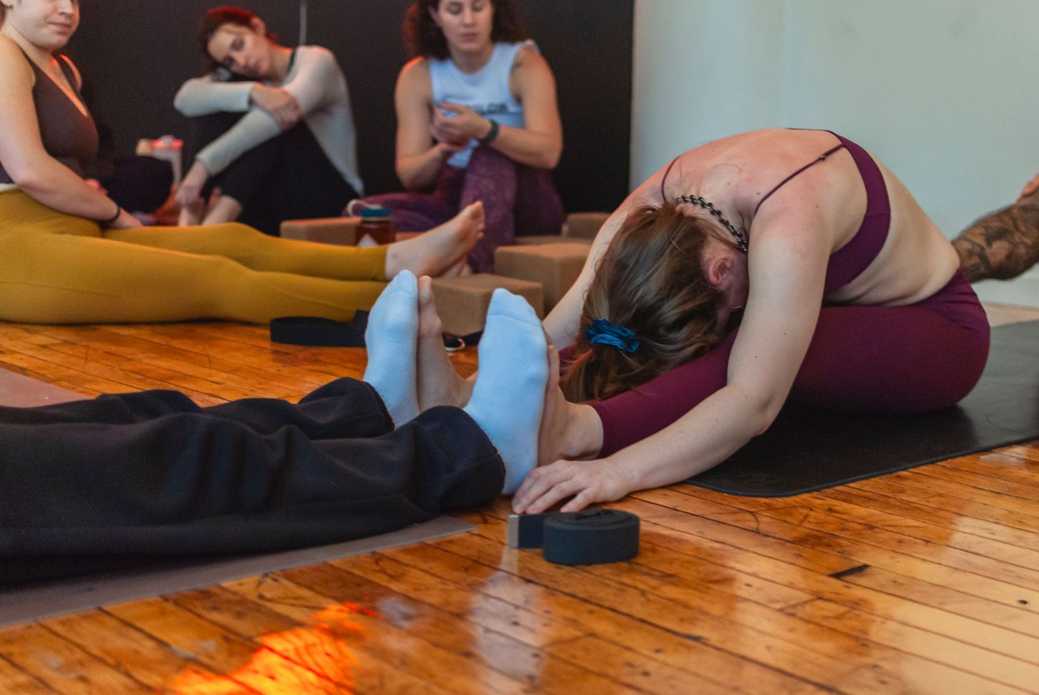 Yoga teacher assisting a student during a yoga workshop in a studio located in Hartford, CT