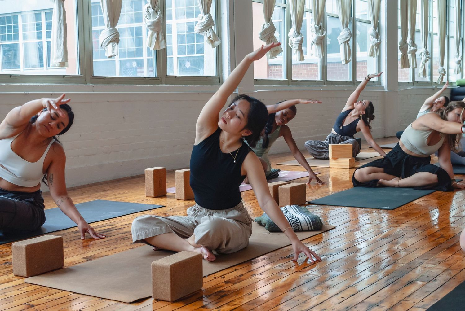 Group yoga class practicing together in a yoga studio